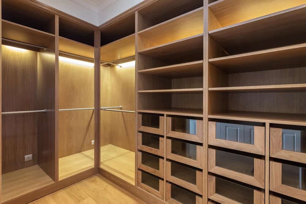 A fitted reach-in closet with shelving above a hanging rail