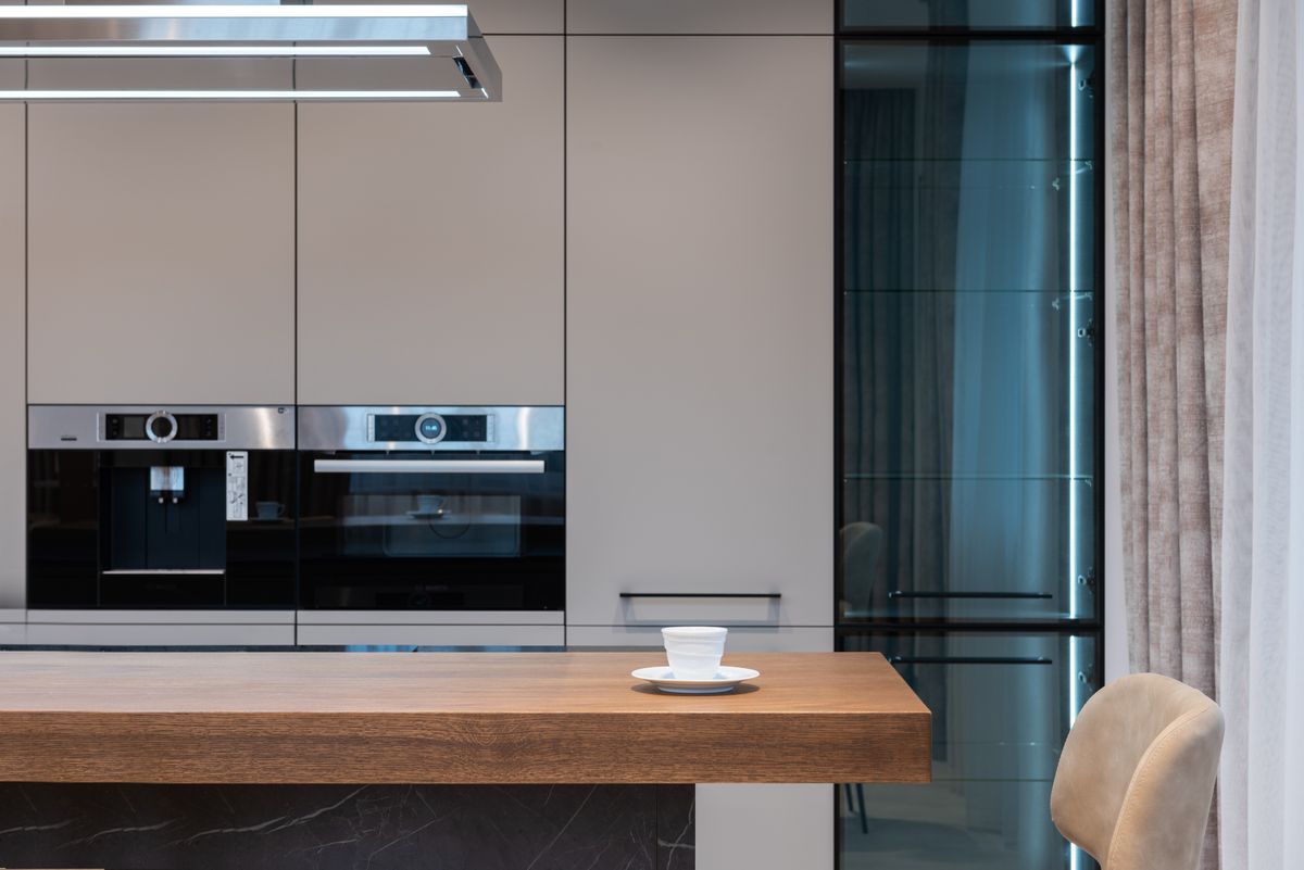 Timber island counter facing built-in ovens