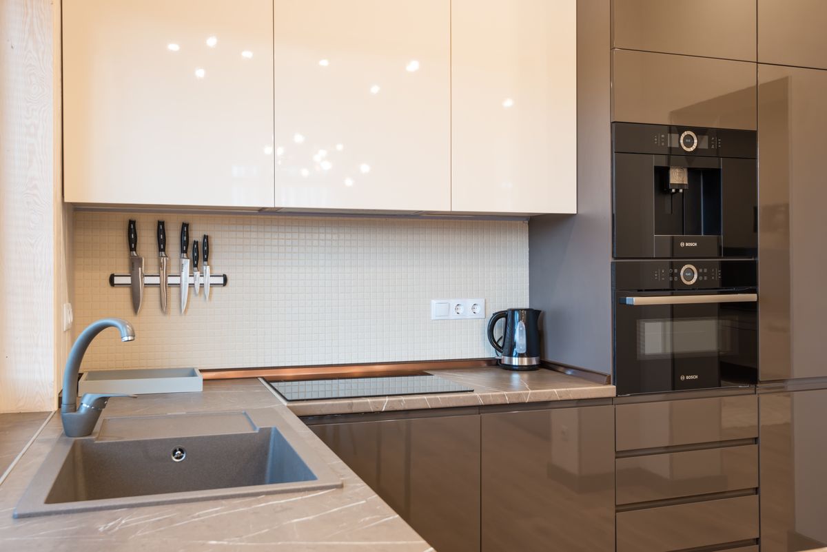 Gloss cabinets with a stone worktop and built-in ovens