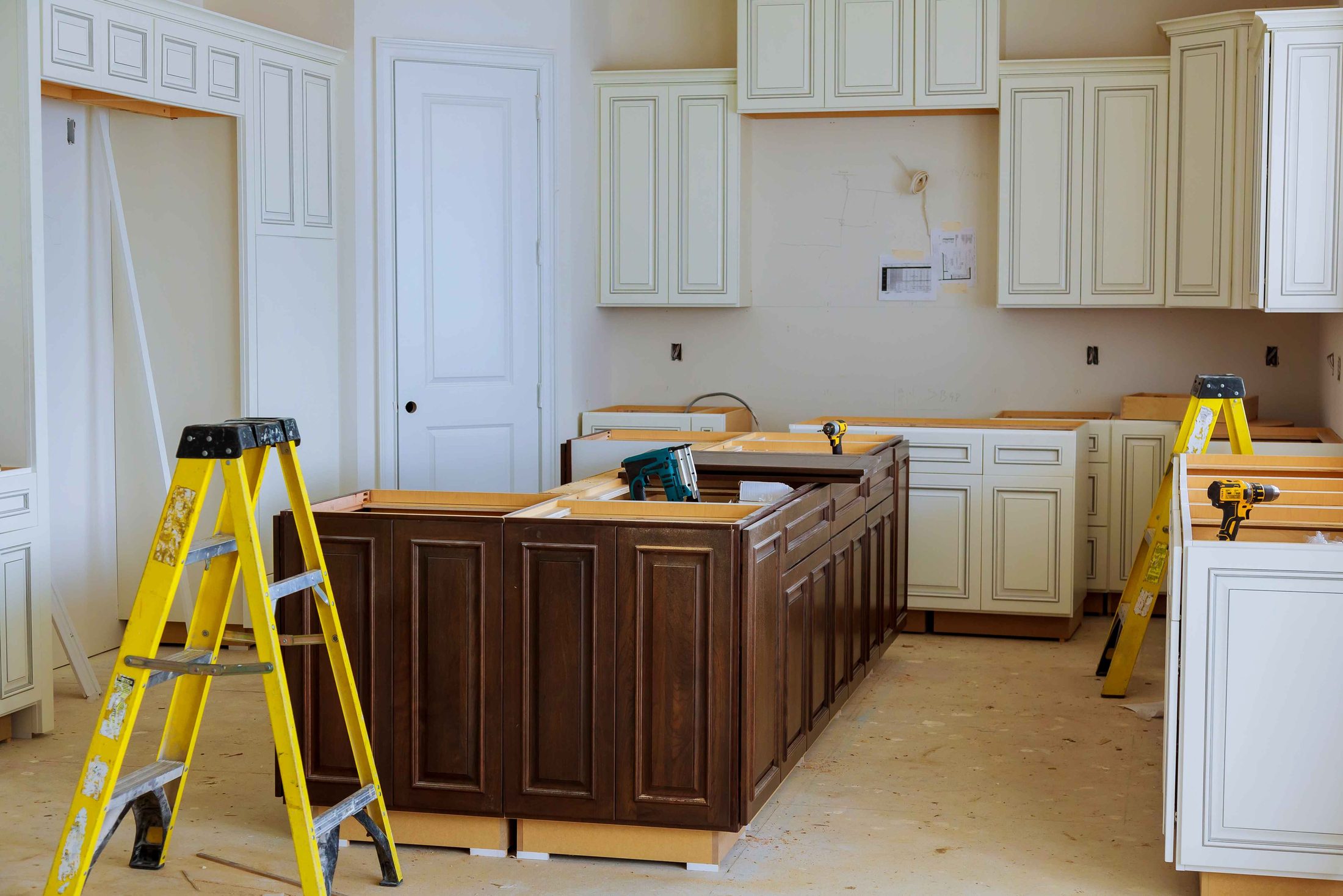 Cabinets going in during a kitchen installation, ladders and tools still on site