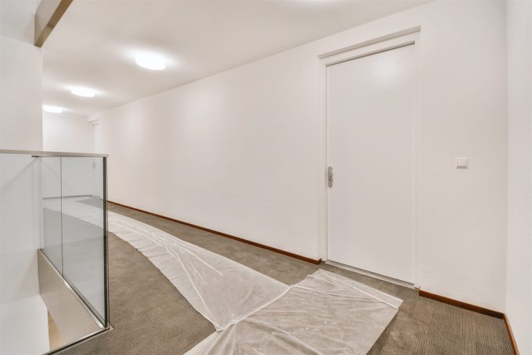 Hallway floor covered with protective plastic along the crew path during a remodel
